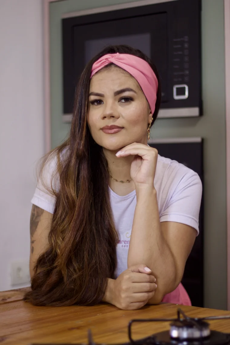 Karen Munhoz na cozinha, apoiada na bancada
